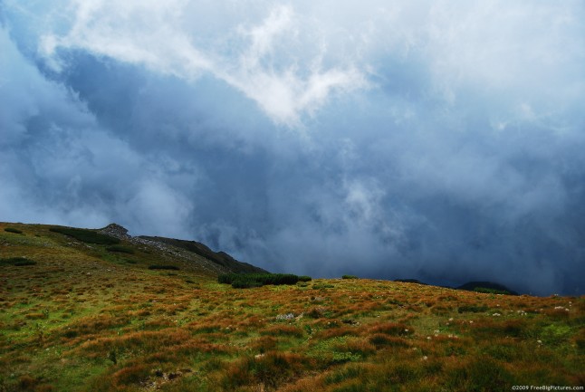Stormy clouds on the sky over a mountain ridge covered with grass