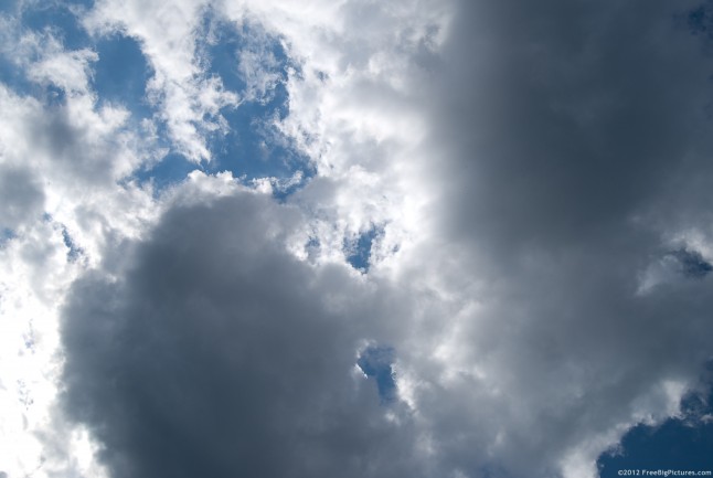 A cloud in white and gray over a blue sky